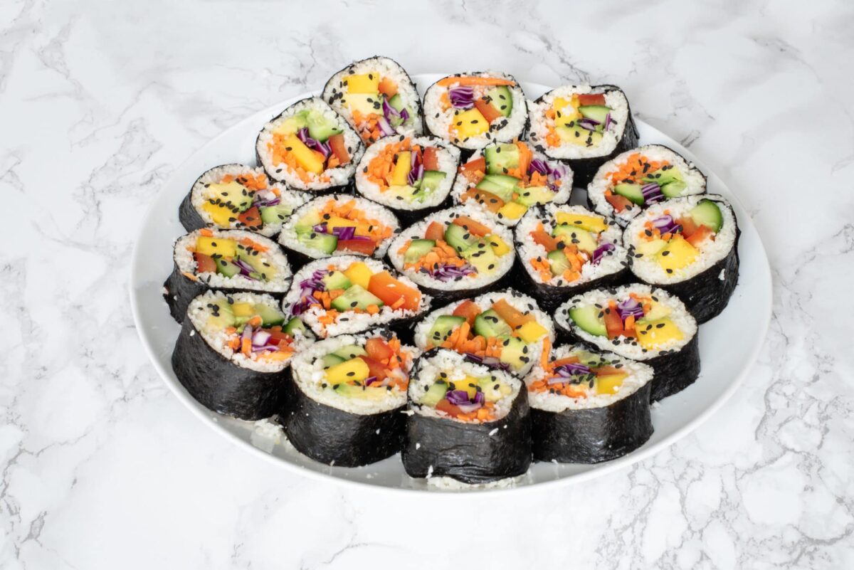 A white plate filled with vegetable sushi pieces.