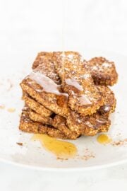 A stack of french toast sticks topped with maple syrup.
