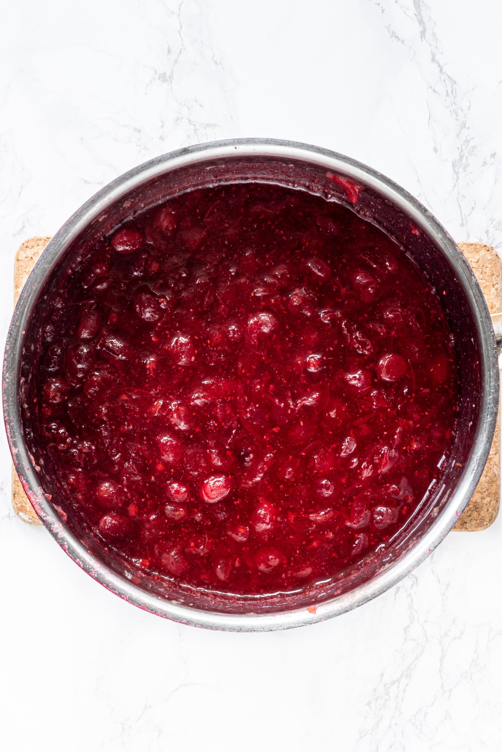 A silver pot of cranberry sauce.