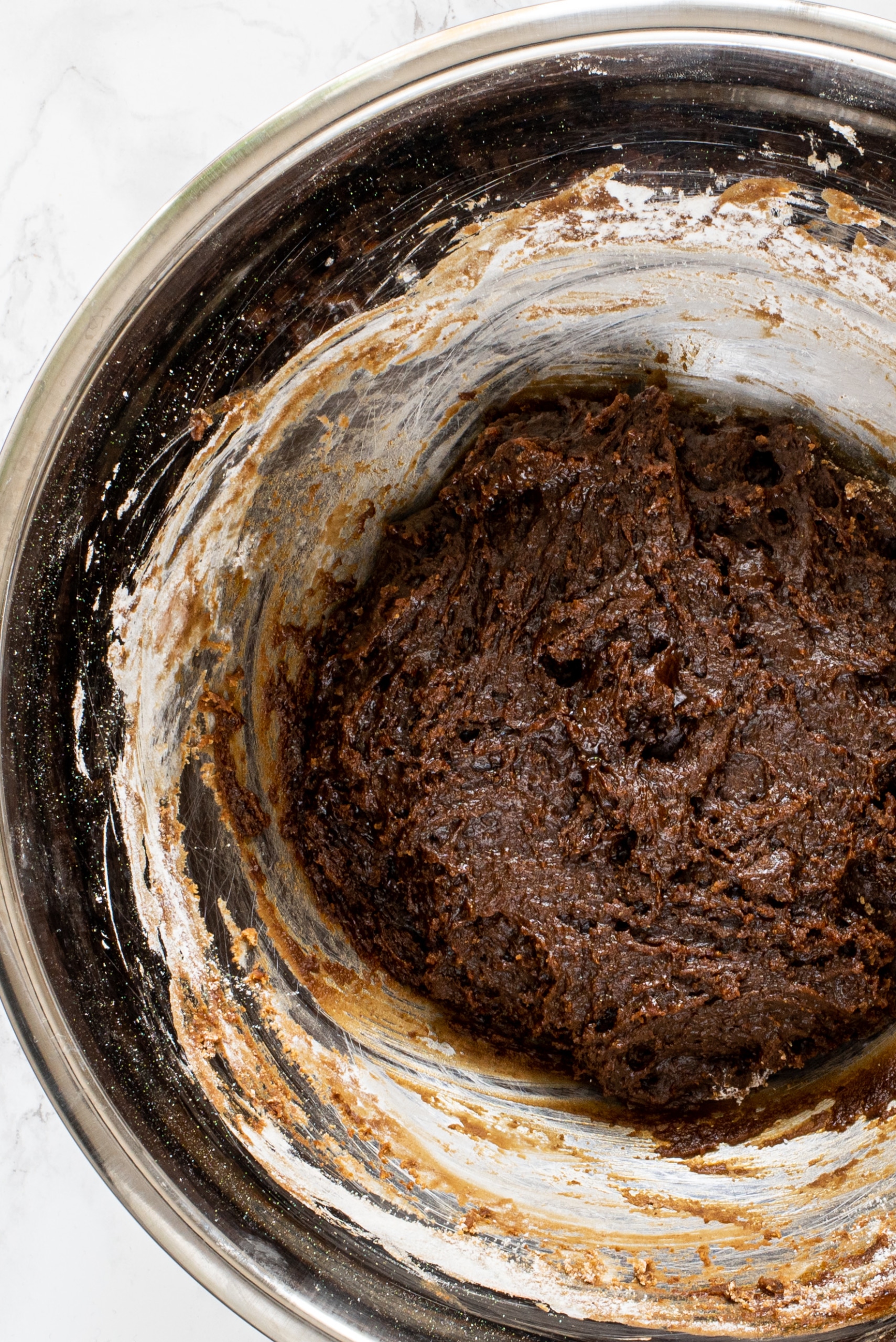 A silver bowl filled with gingerbread cookie dough.