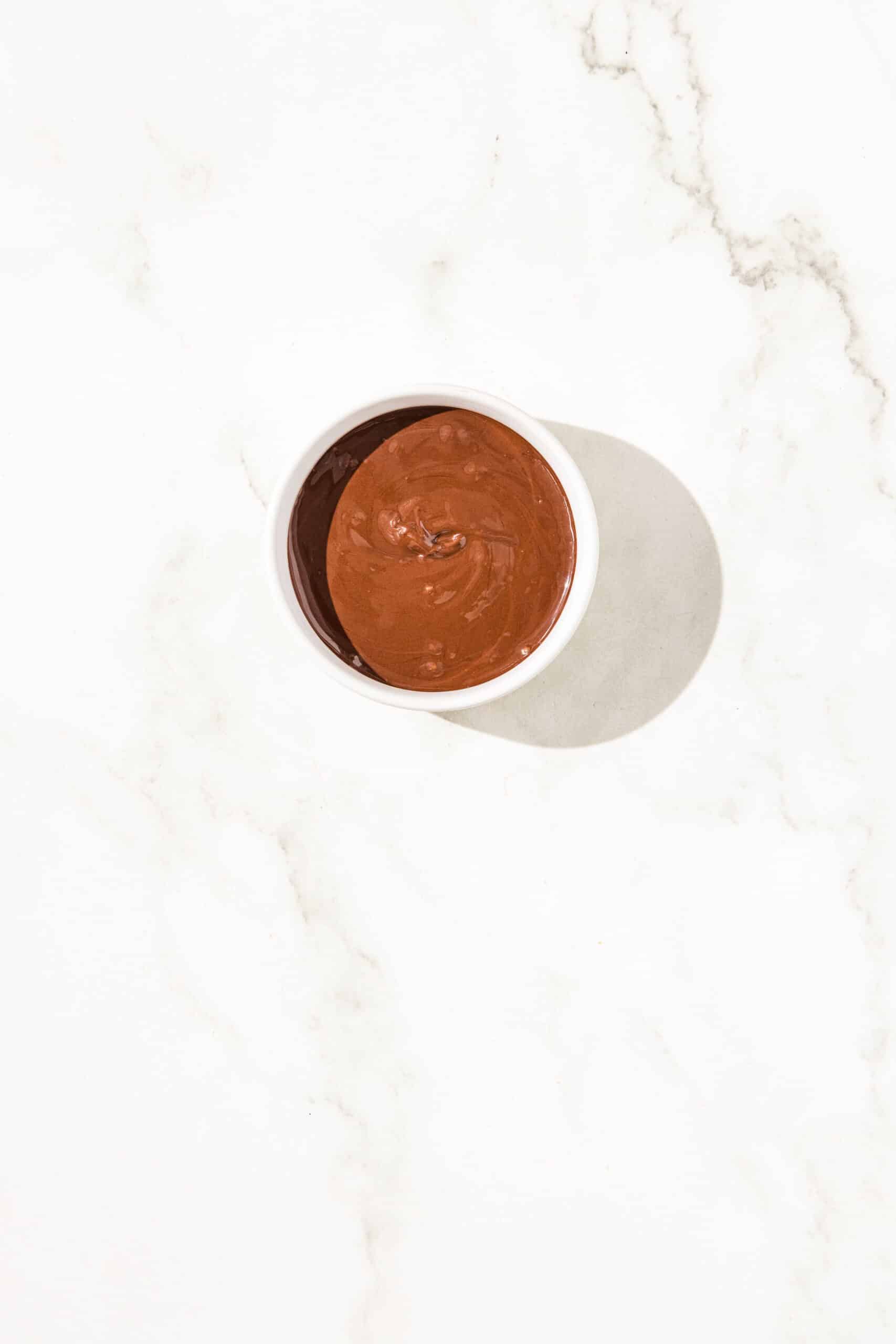 A small white bowl filled with melted chocolate.
