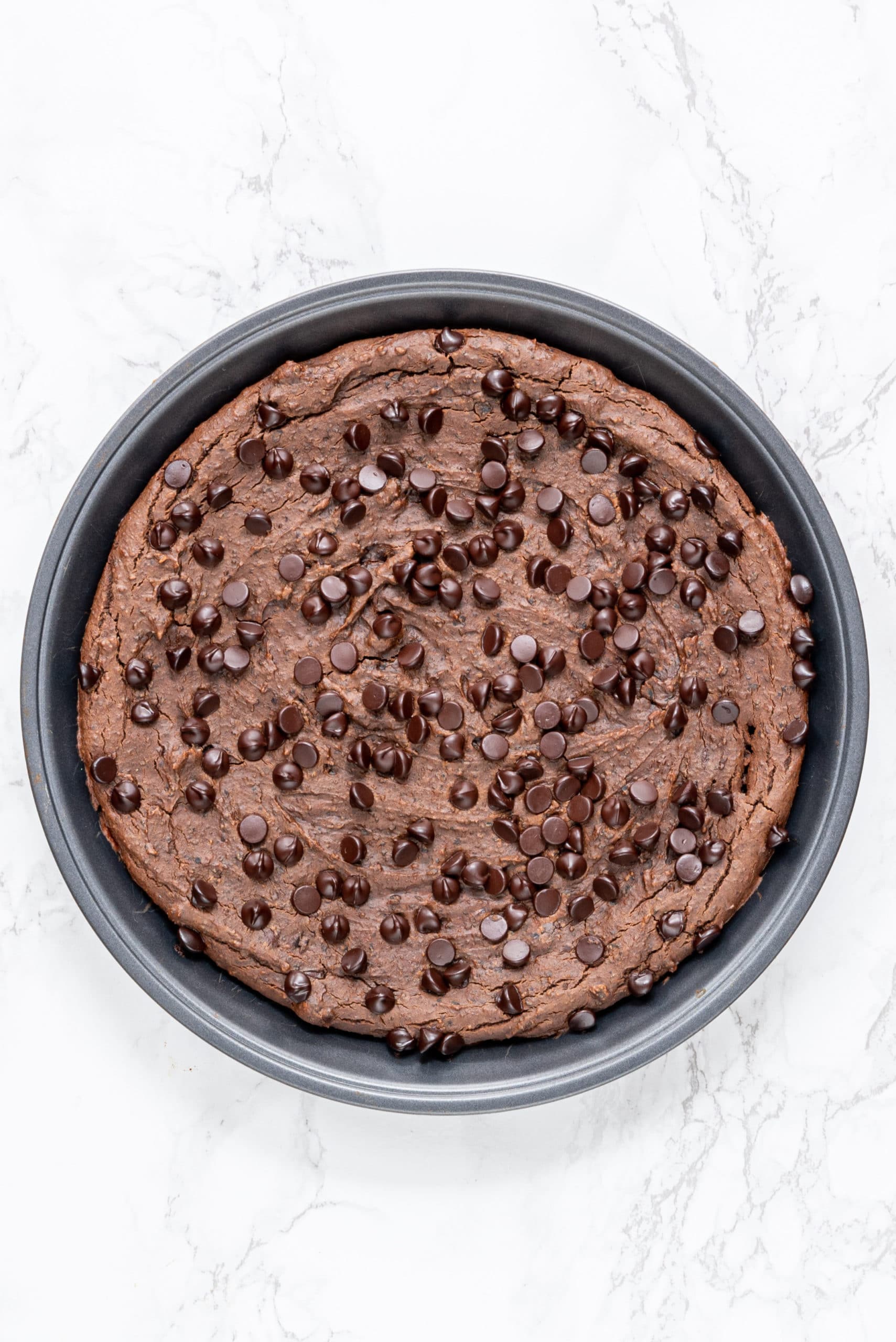 A round pan of Vegan Black Bean Brownies topped with chocolate chips.