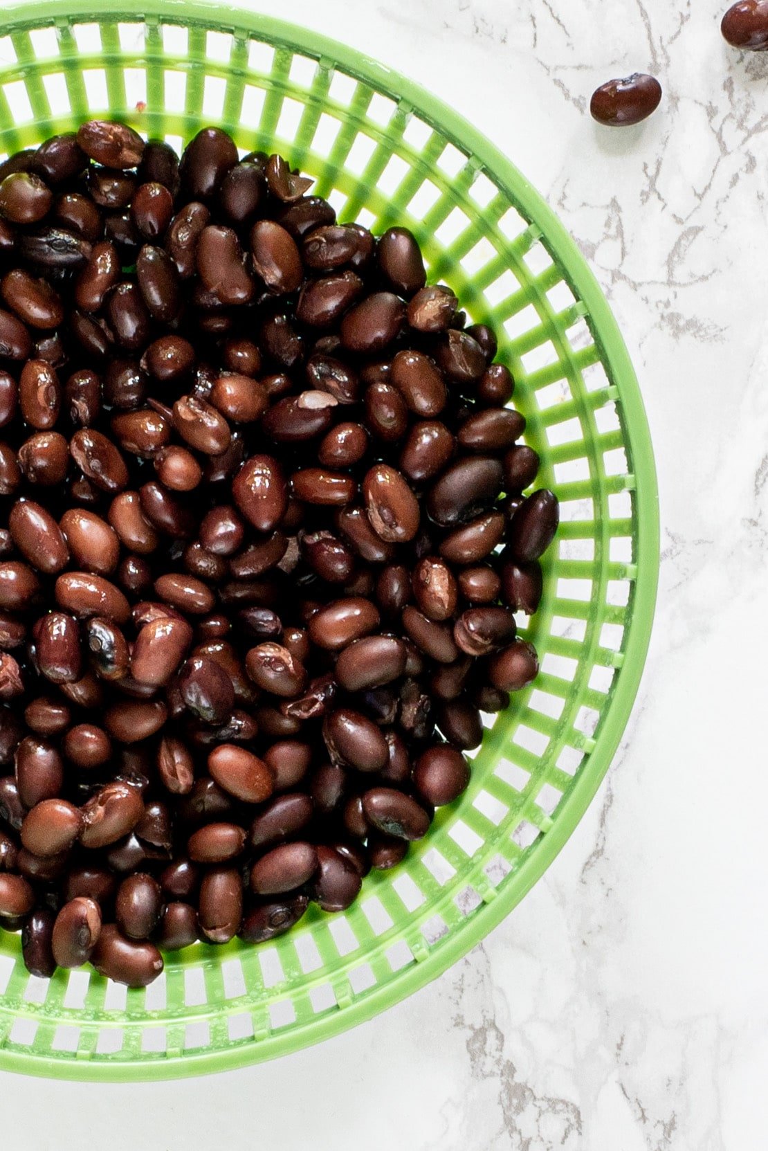 black beans in a green plastic colander.