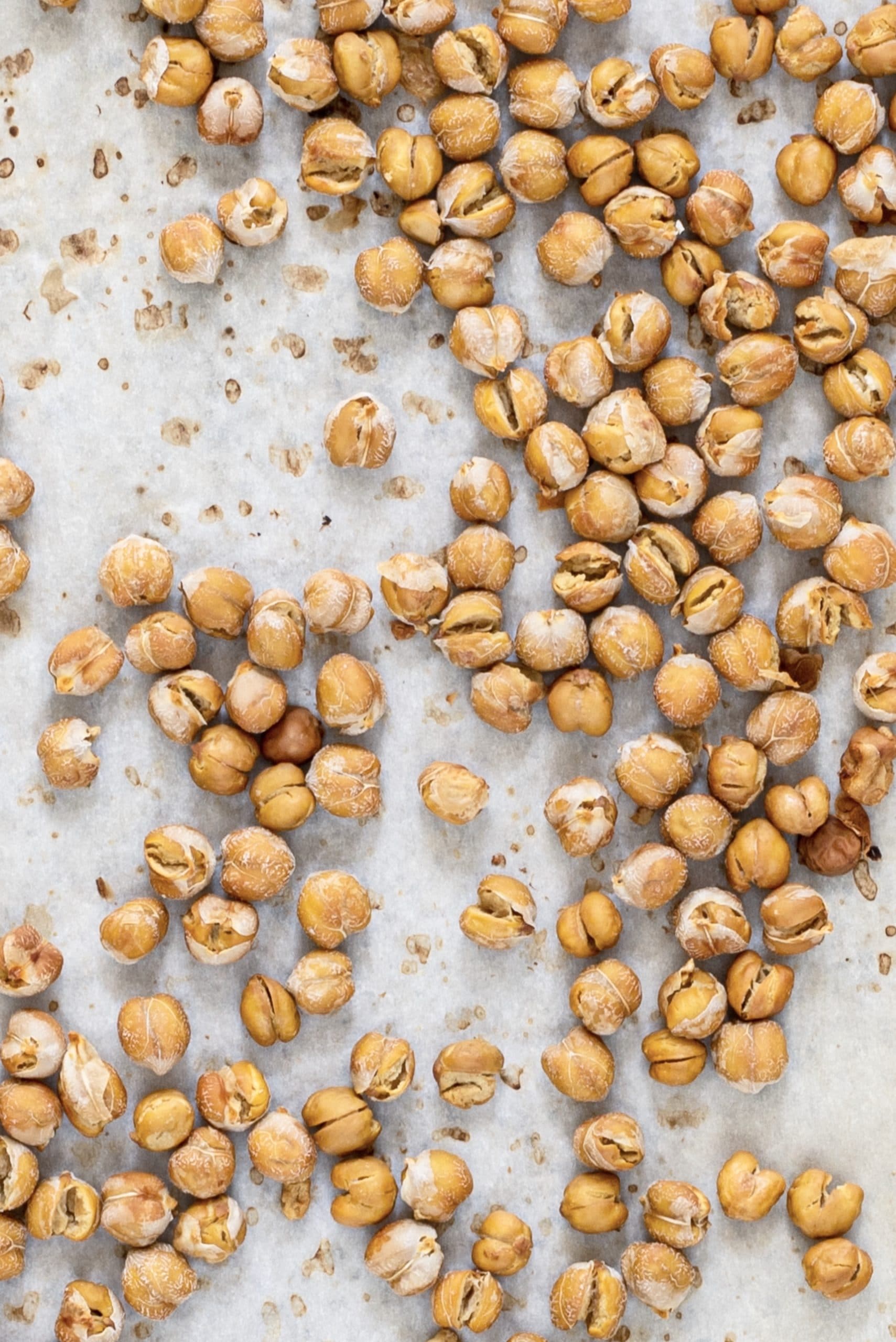 A piece of parchment paper with crispy chickpeas on it.