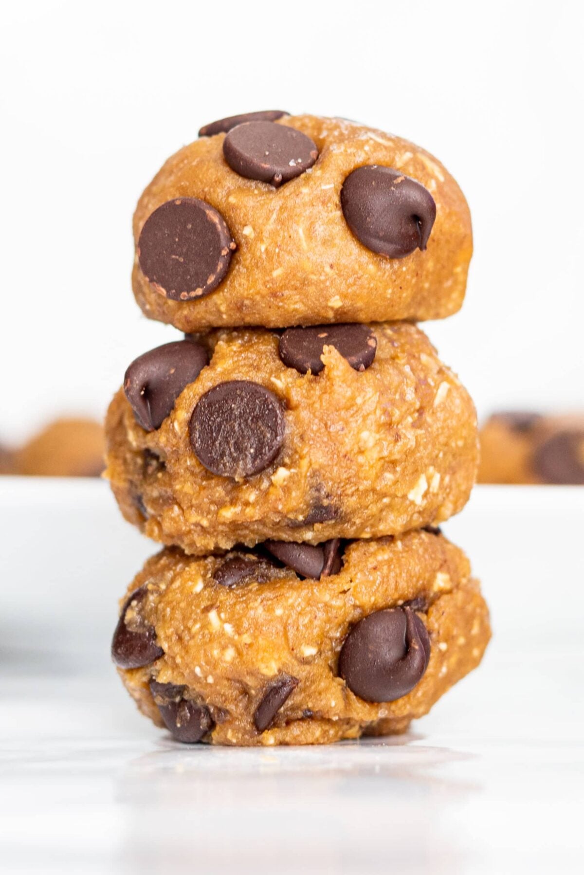 Three cookie dough bites stacked on top of each other.