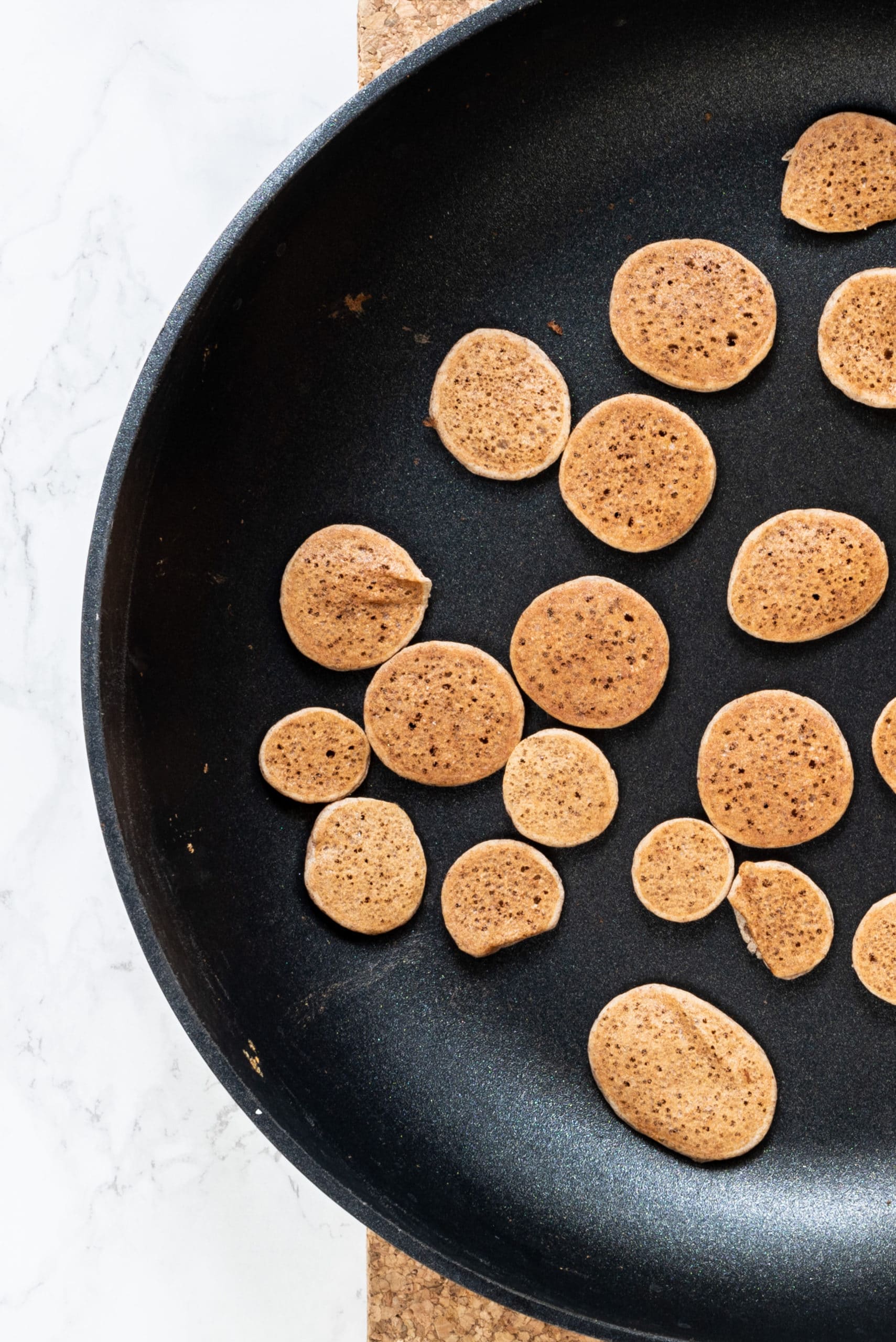 A pan filled with mini pancakes.