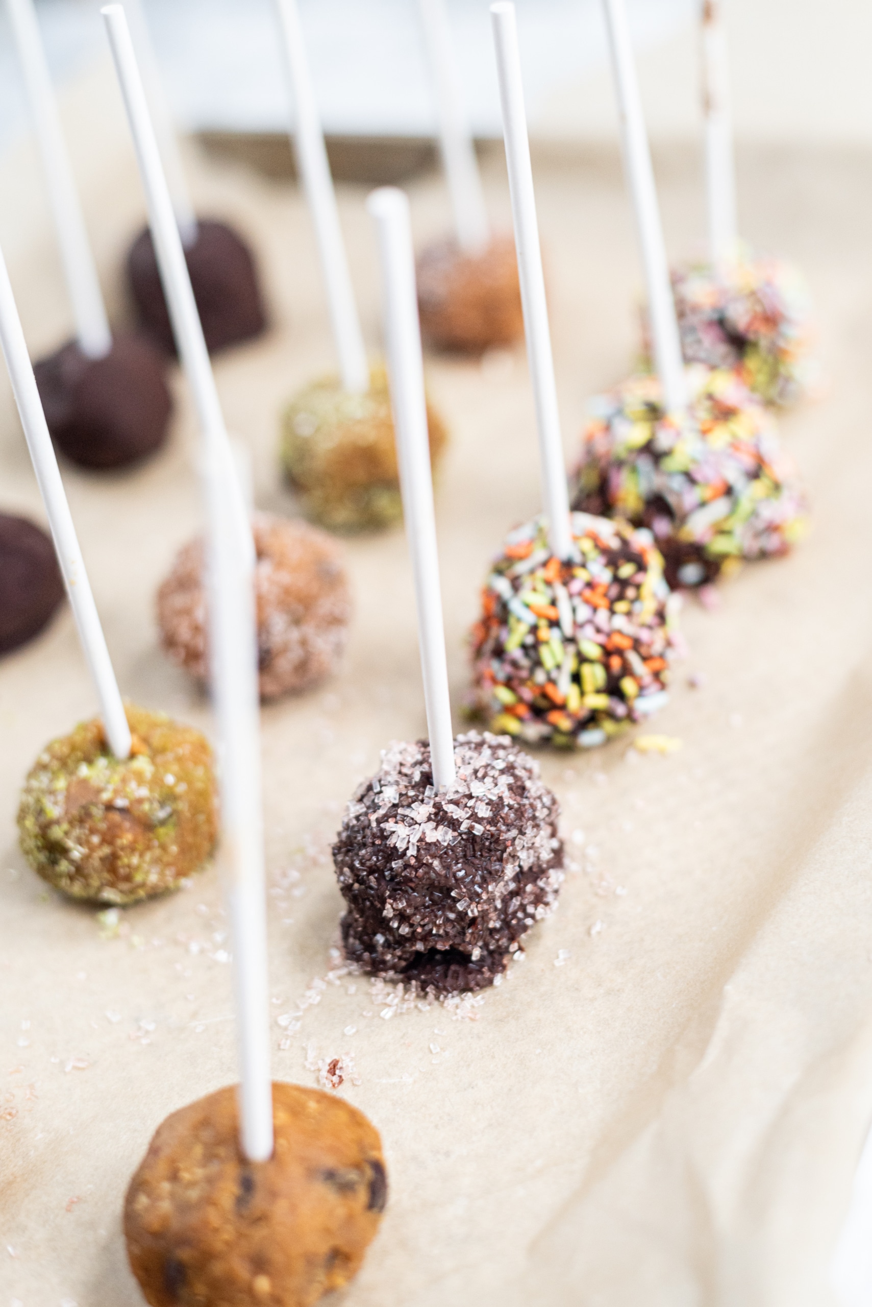 A pan filled with chocolate covered cookie dough pops.
