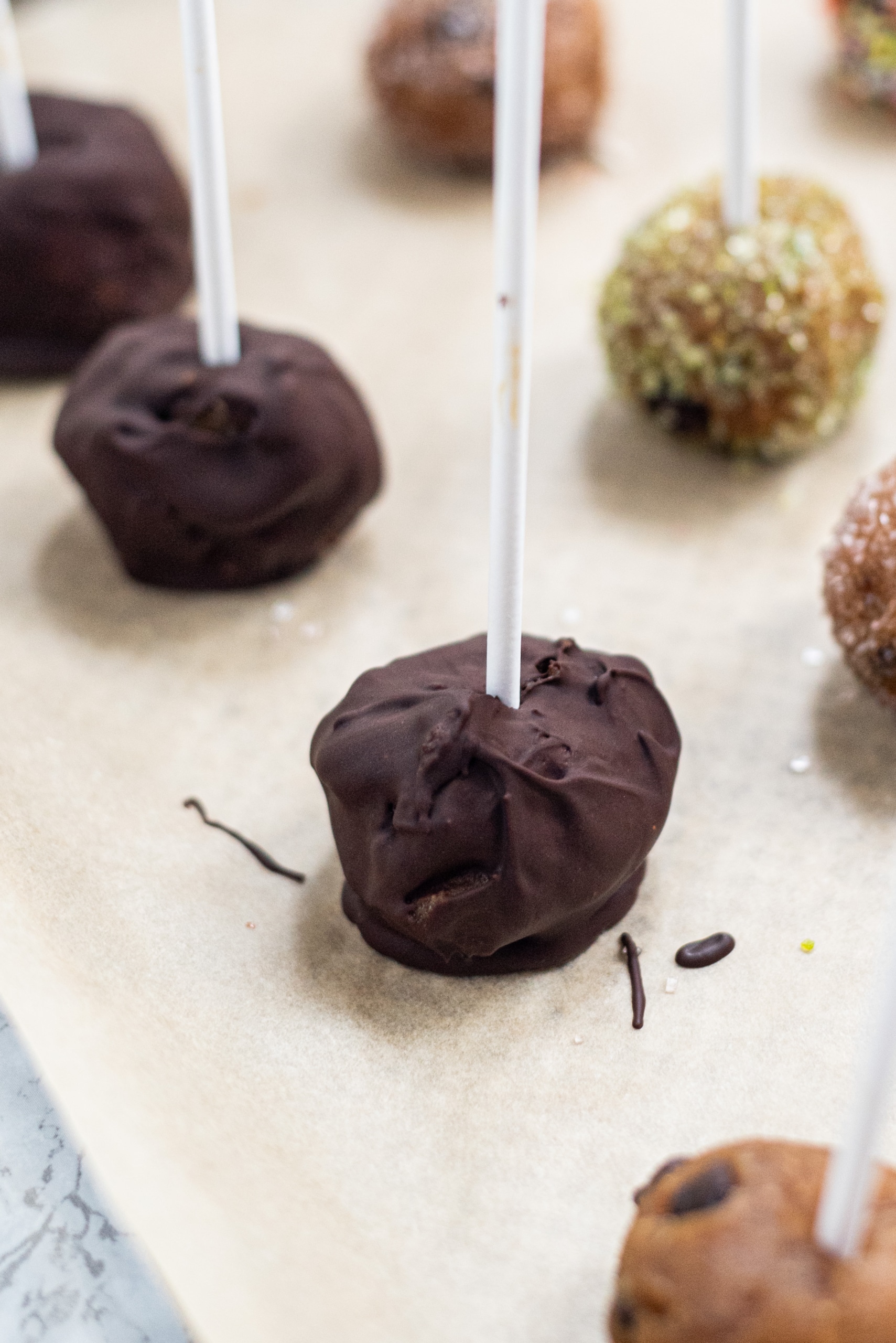 A pan with chocolate covered cookie dough pops on it.