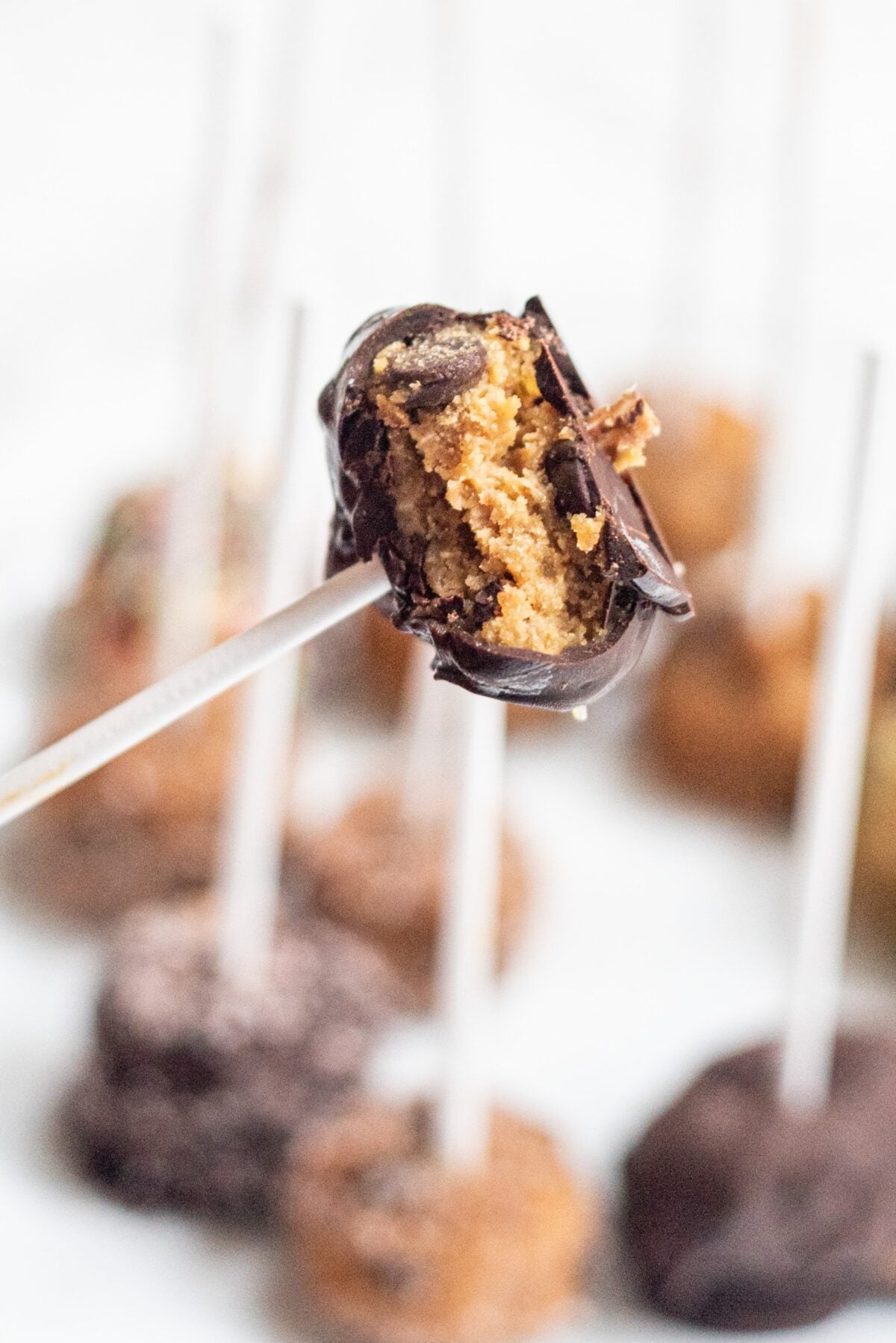 A cookie dough pop on a stick dipped in chocolate.