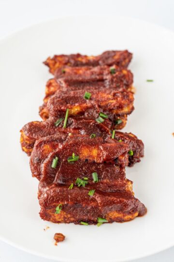 A white plate with a stack of Vegan BBQ Tempeh Ribs.