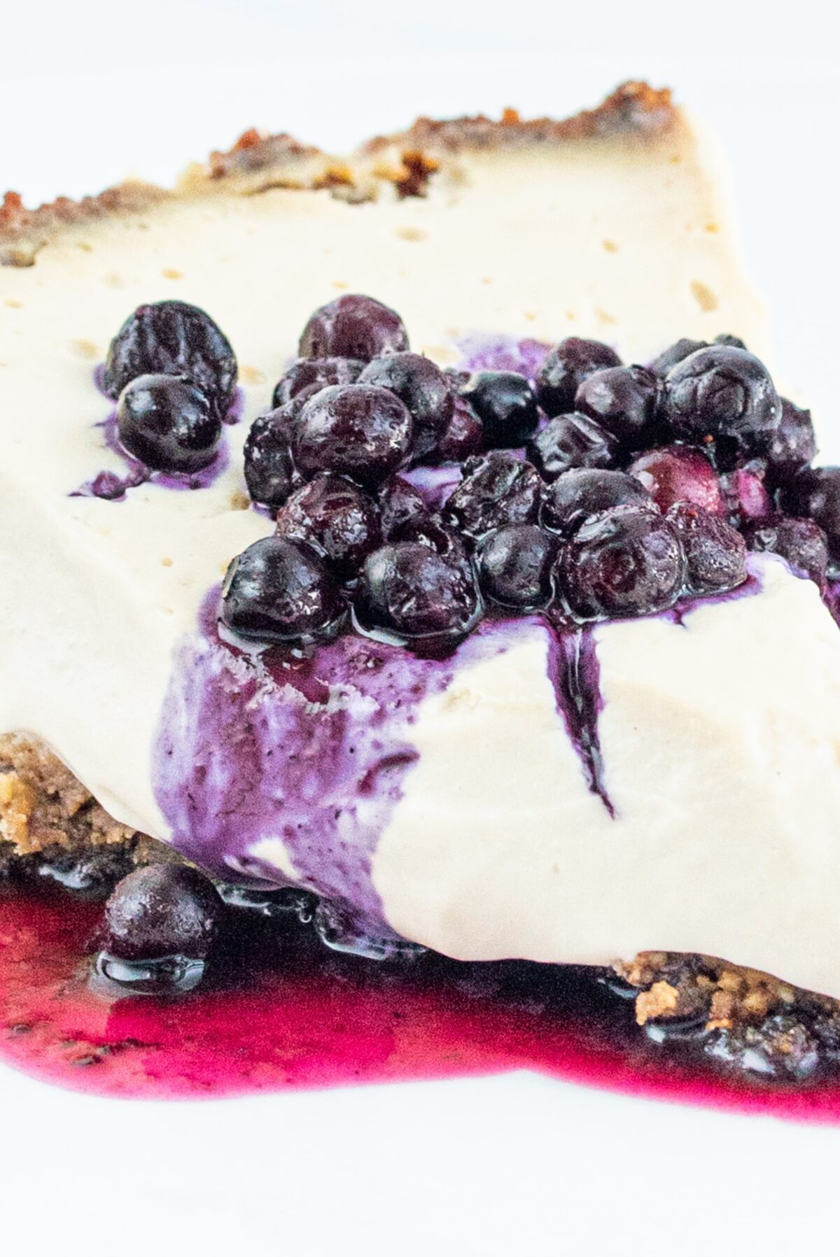 A slice of vanilla pie topped with blueberries.