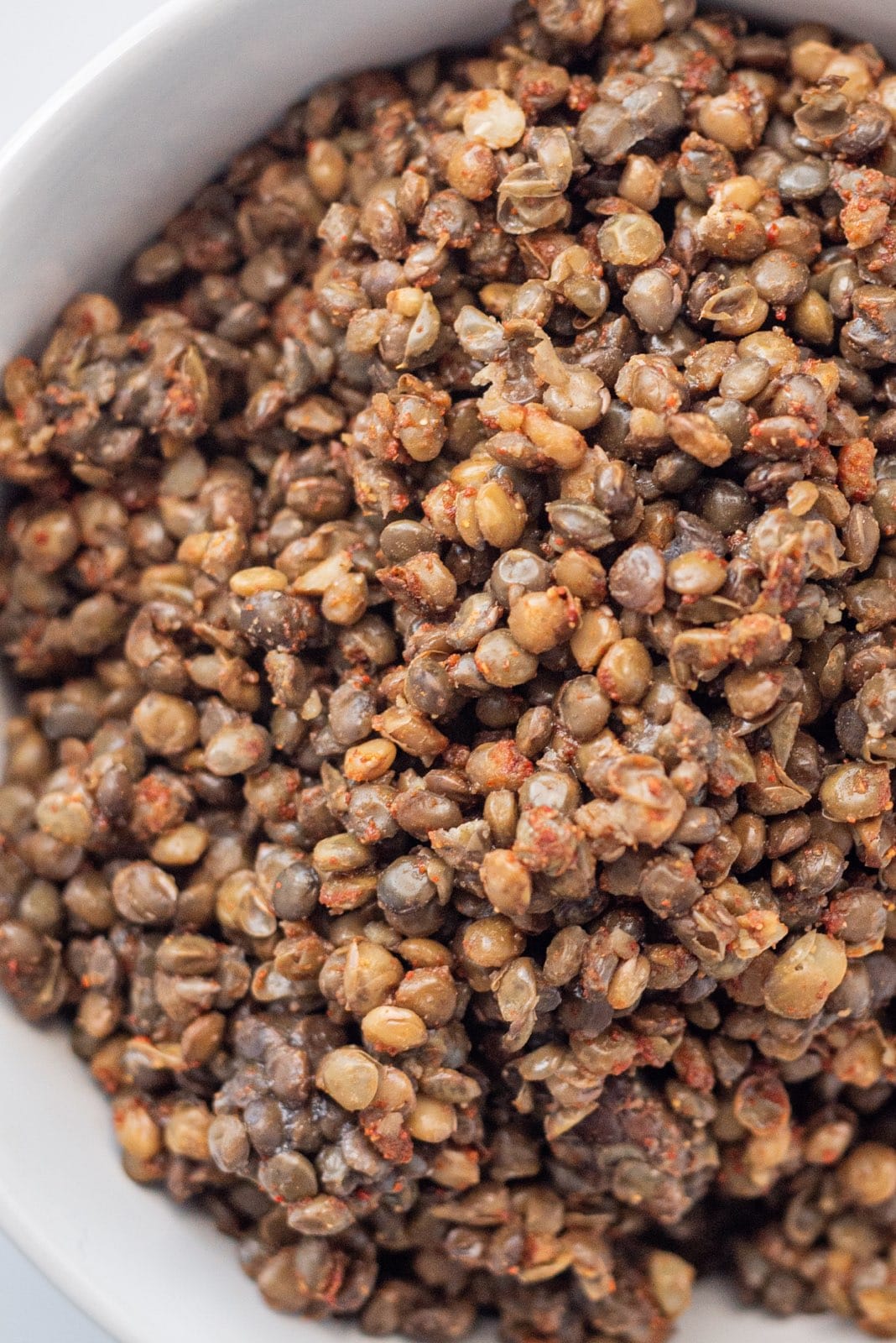 Lentils in a glass white bowl.
