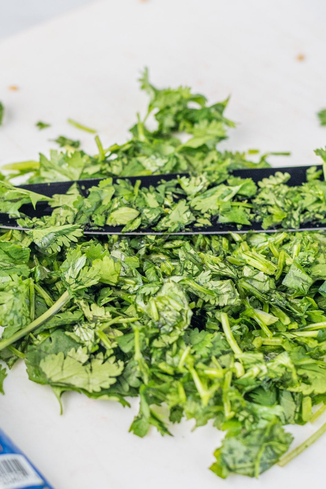 A cutting board with chopped cilantro on it.