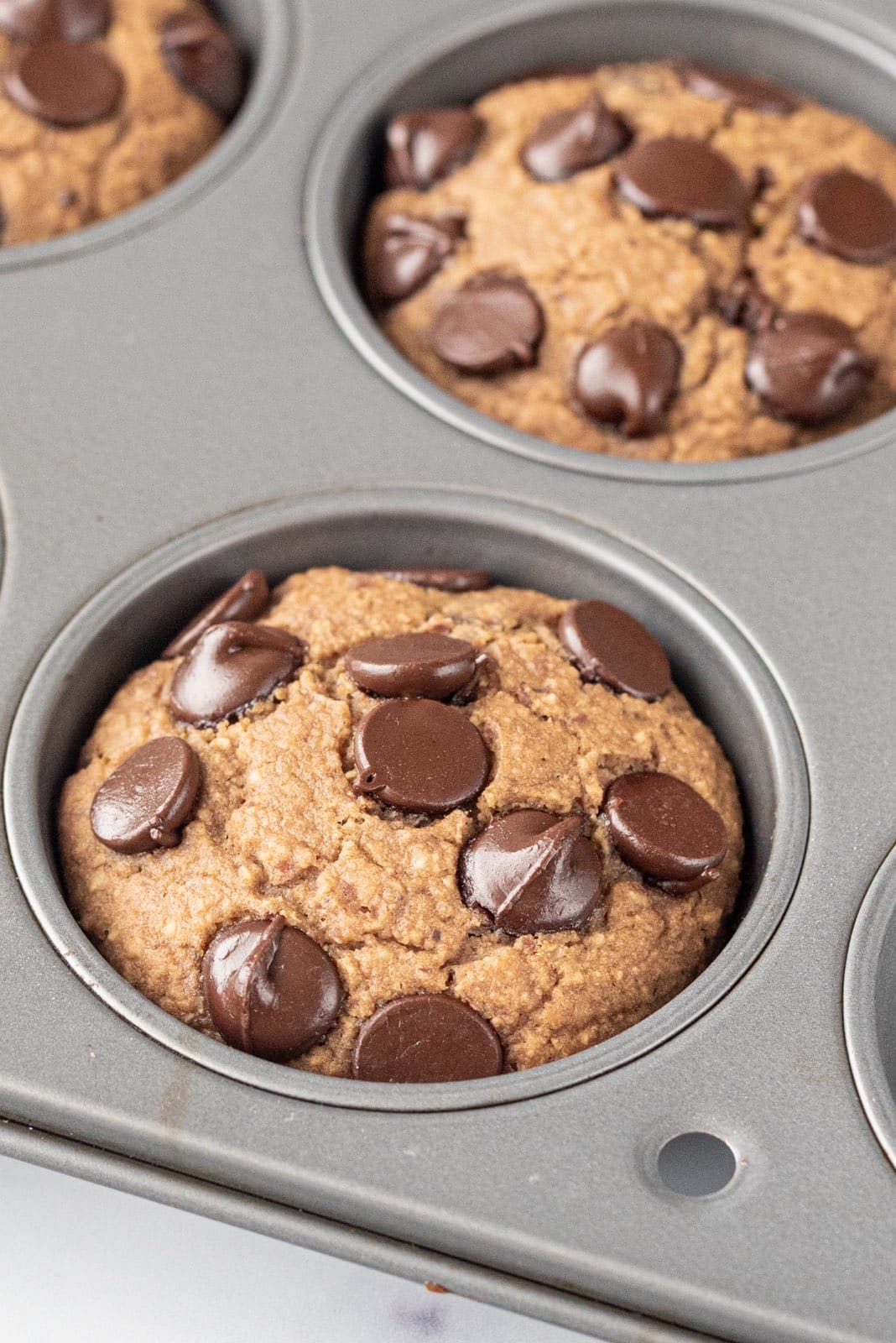 A muffin tin filled with chocolate chip muffins.