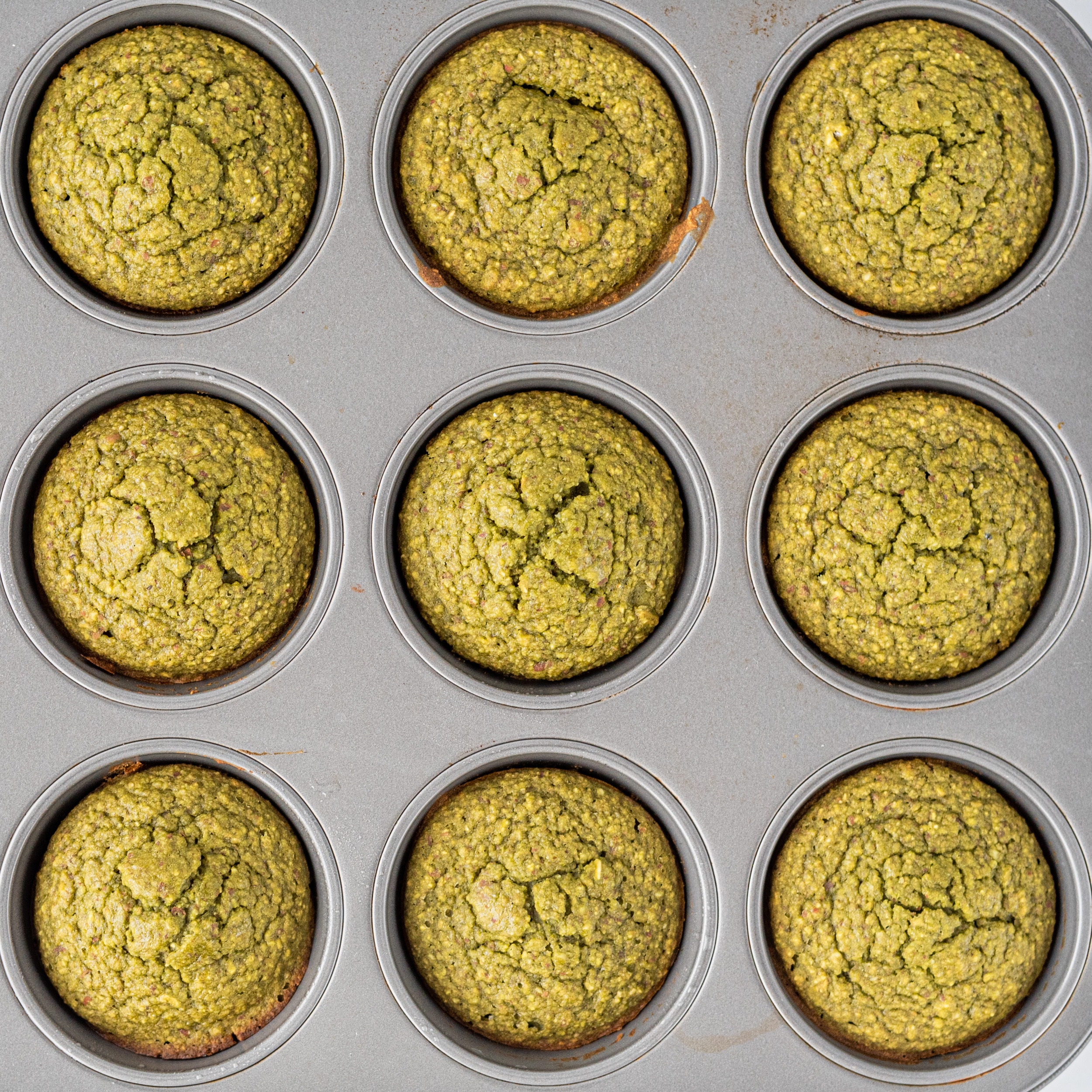 A muffin tin filled with matcha muffins.