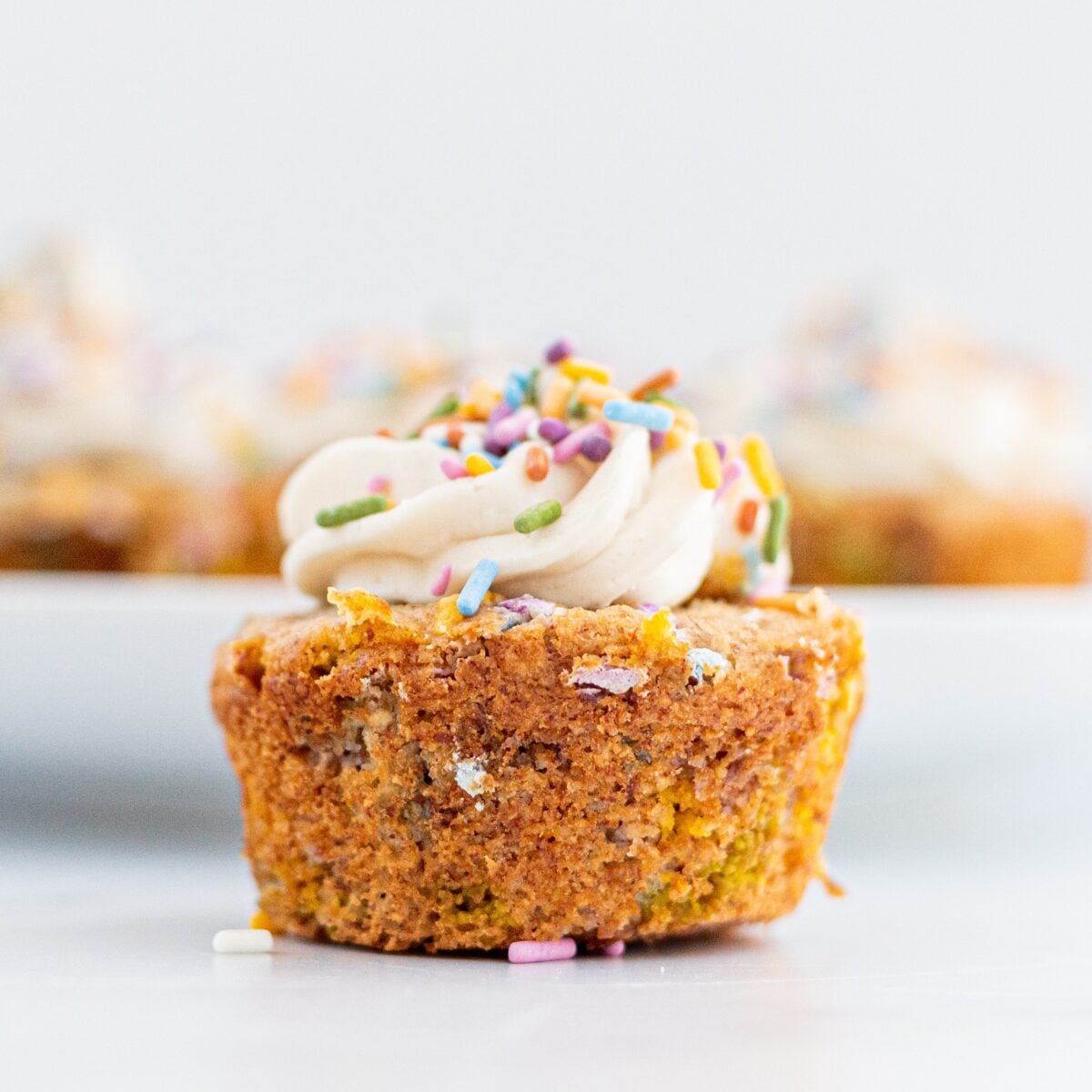 A funfetti muffin topped with frosting and sprinkles.