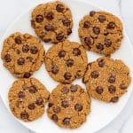 A white plate with 7 pumpkin chocolate chip cookies on it.