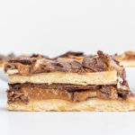 Two Vegan Gluten-Free Twix Bars stacked on top of each other with a few bars behind them in the background.