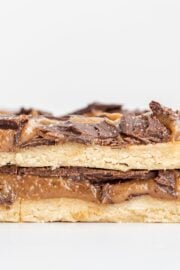 Two Vegan Gluten-Free Twix Bars stacked on top of each other with a few bars behind them in the background.