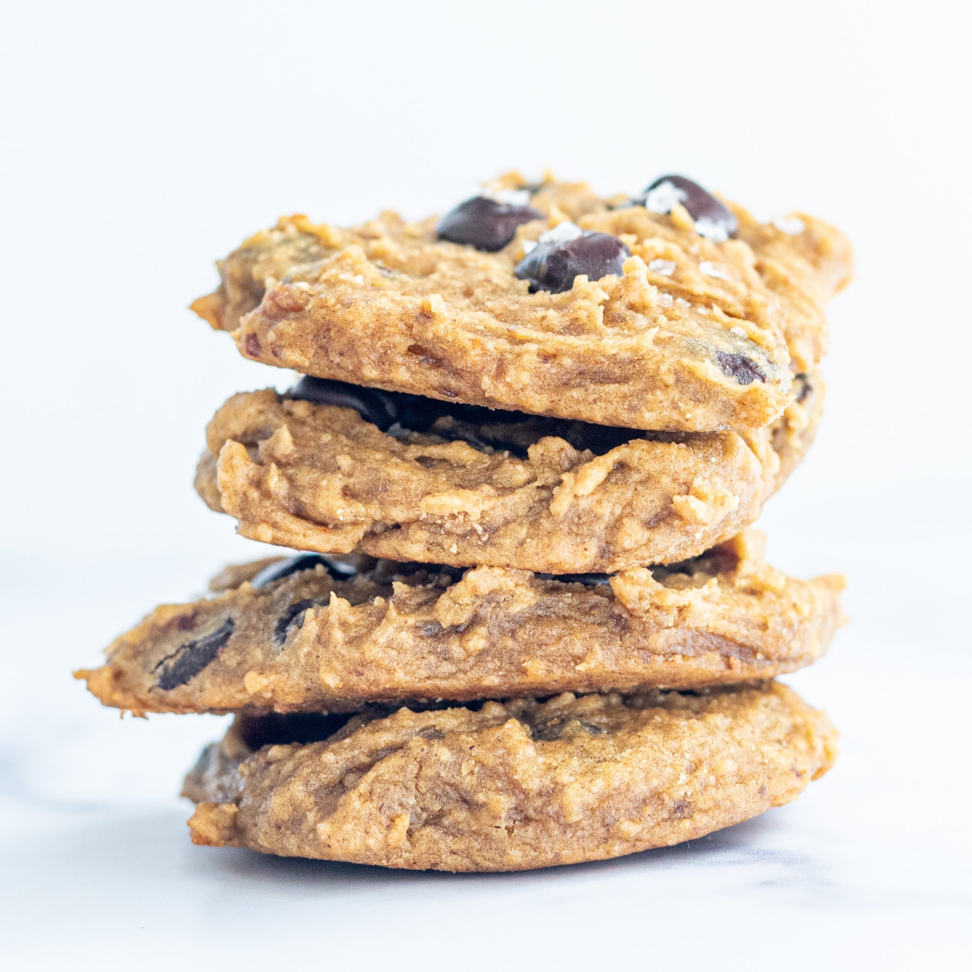 Four Vegan Chickpea Chocolate Chip Cookies stacked up on the counter.