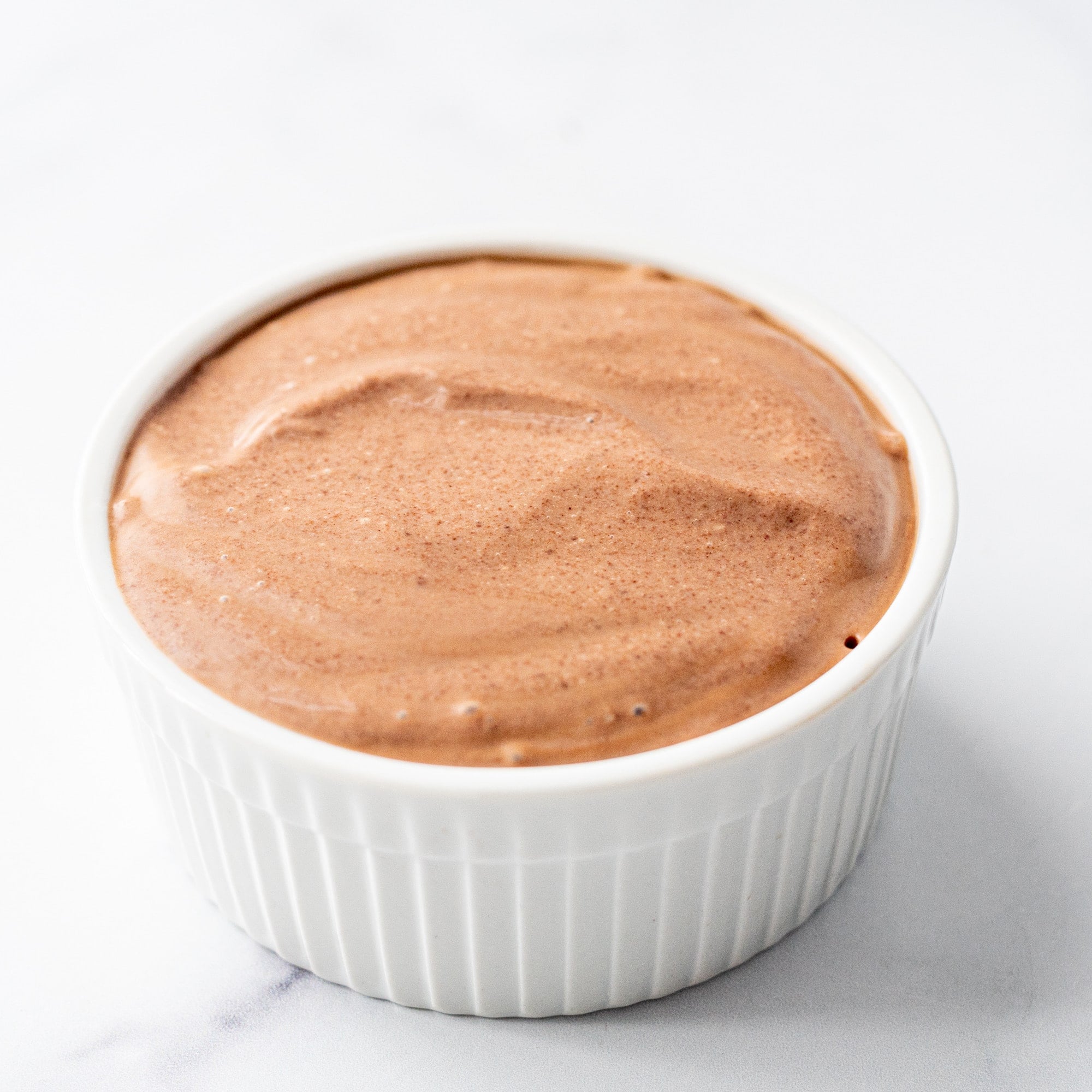 A ramekin dish filled with chocolate mousse.