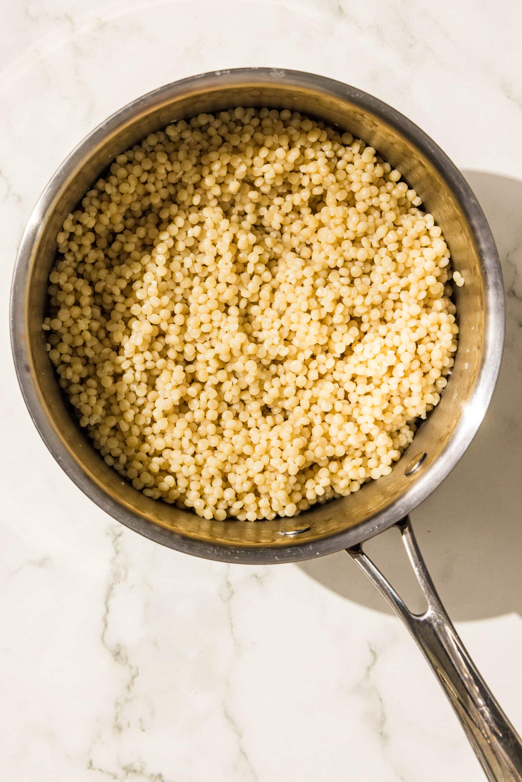 A silver pot of cooked couscous.