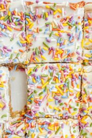 Vegan Gluten-Free Sugar Cookie Bars on a piece of white parchment sliced into 9 squares.