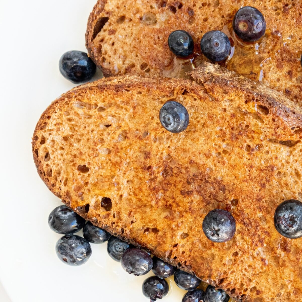Close up of the easy vegan french toast topped with blueberries and maple syrup.