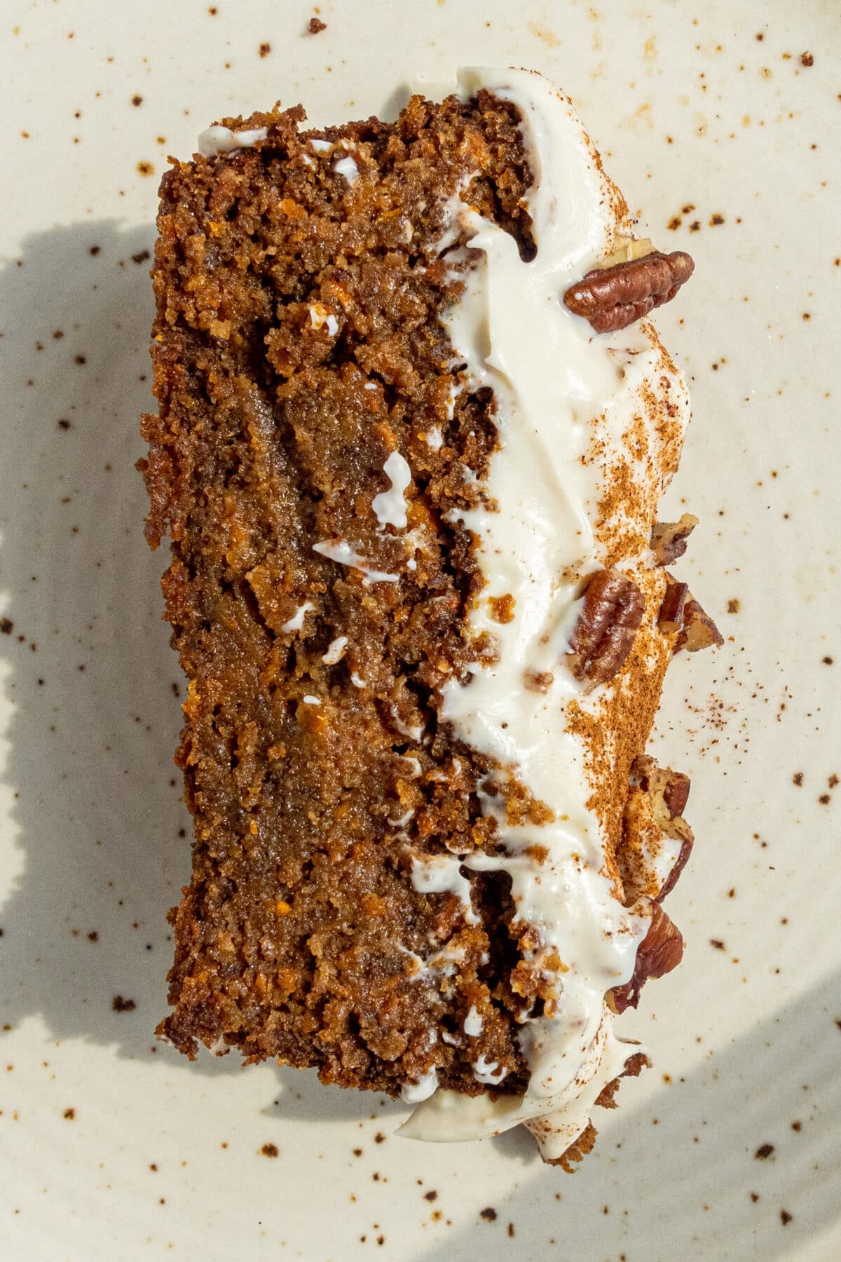 One slice of Vegan Gluten-Free Carrot Cake laid on a plate.