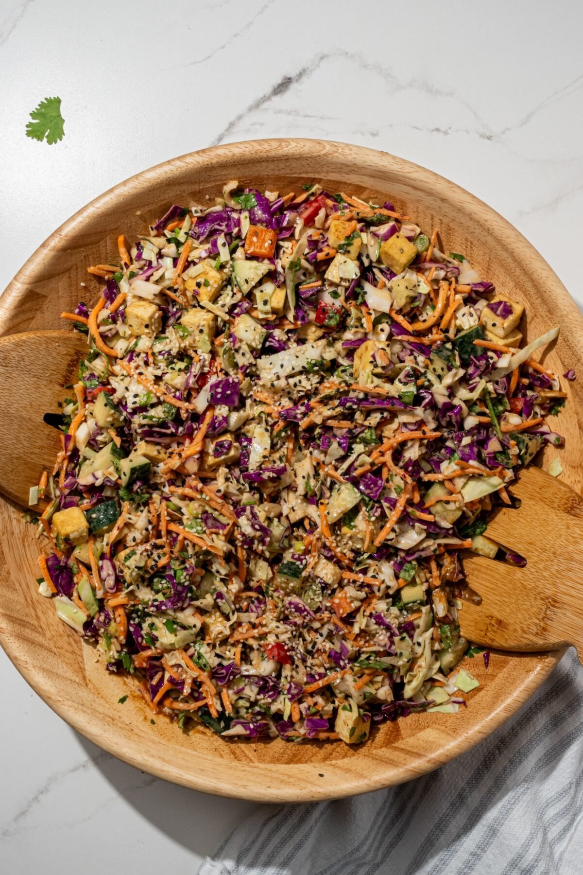 Thai Chopped Salad in a big wooden bowl with two wooden salad tongs.