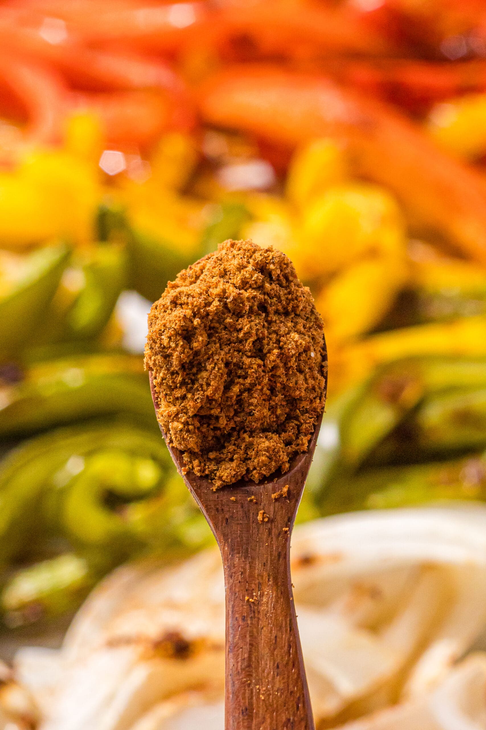 A small wooden spoon with taco seasoning on it.