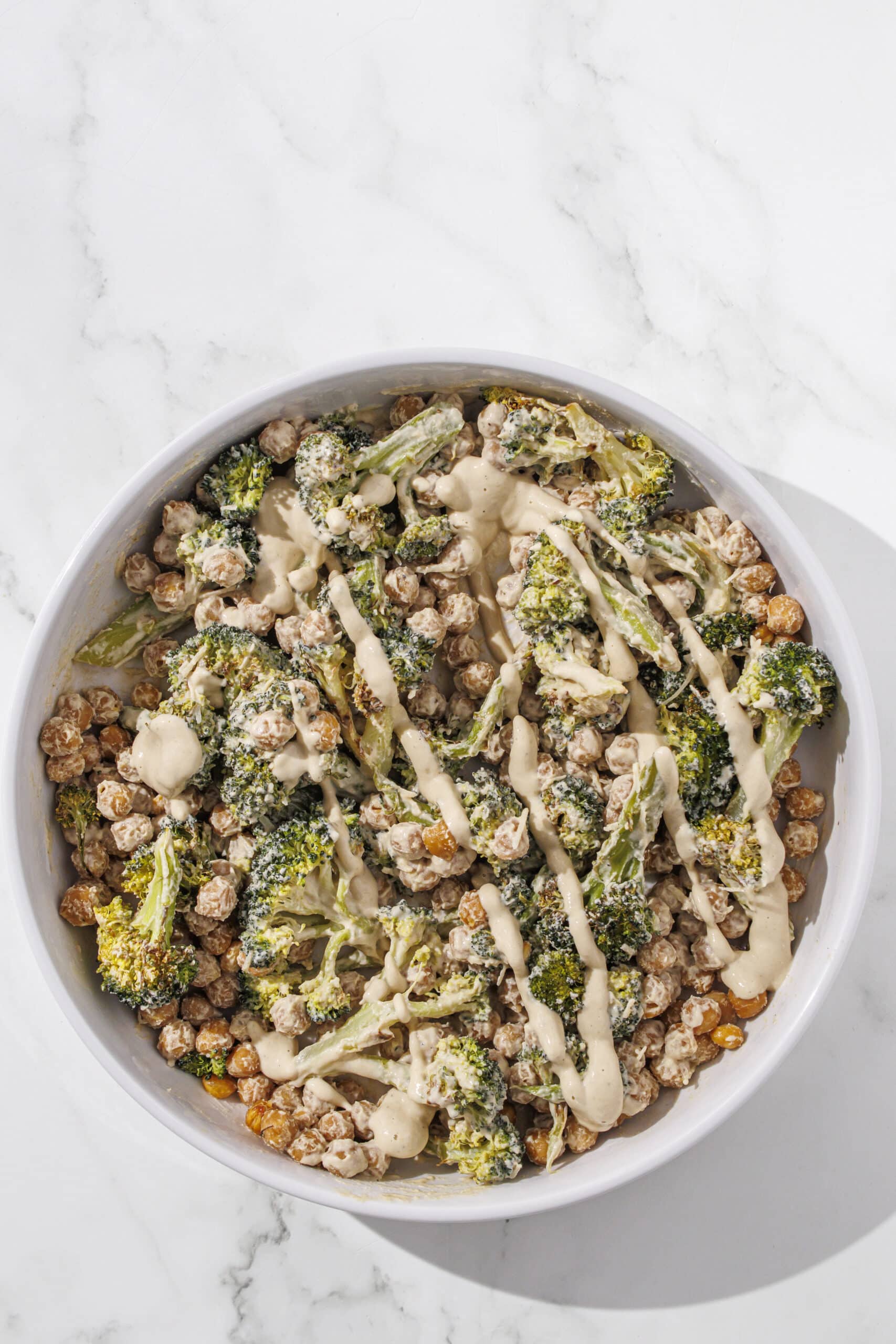 A white bowl filled with broccoli caesar salad.
