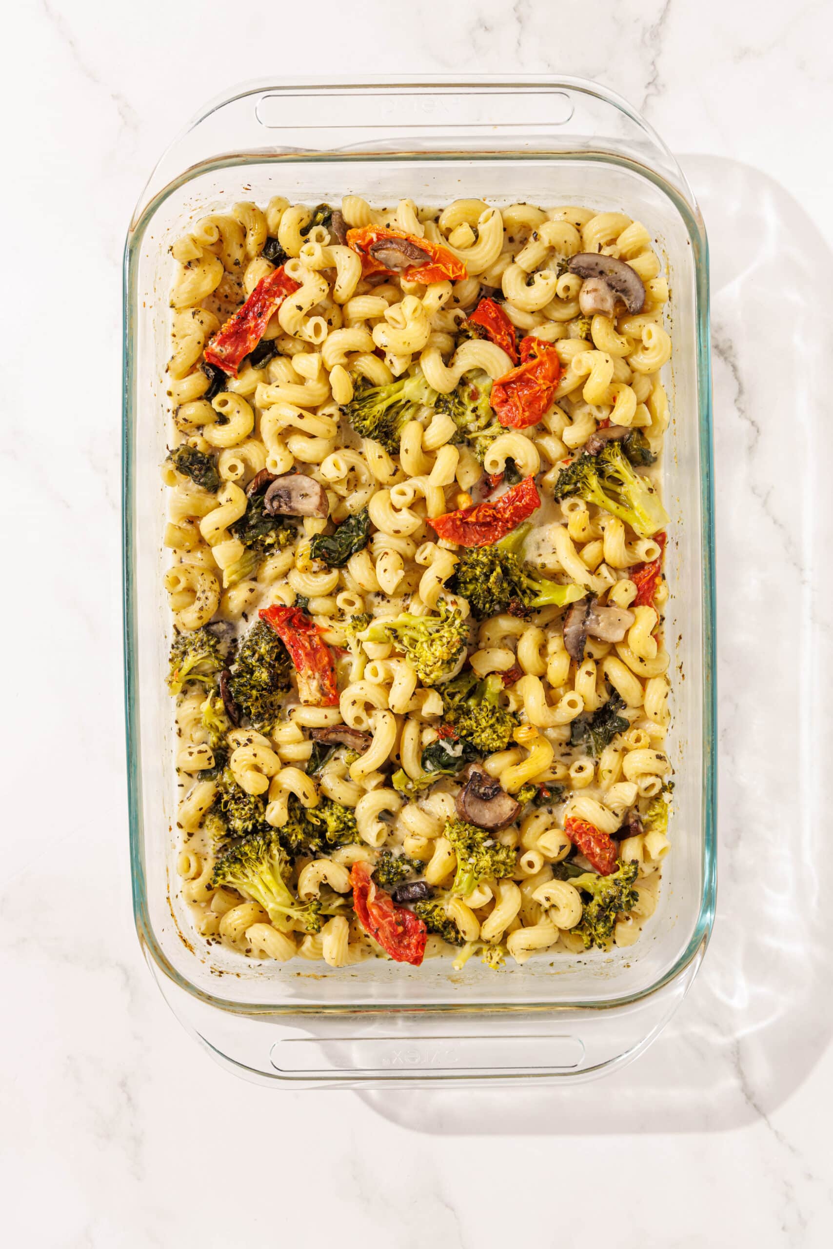 A 9x13 glass baking dish filled with baked one pan tuscan pasta.