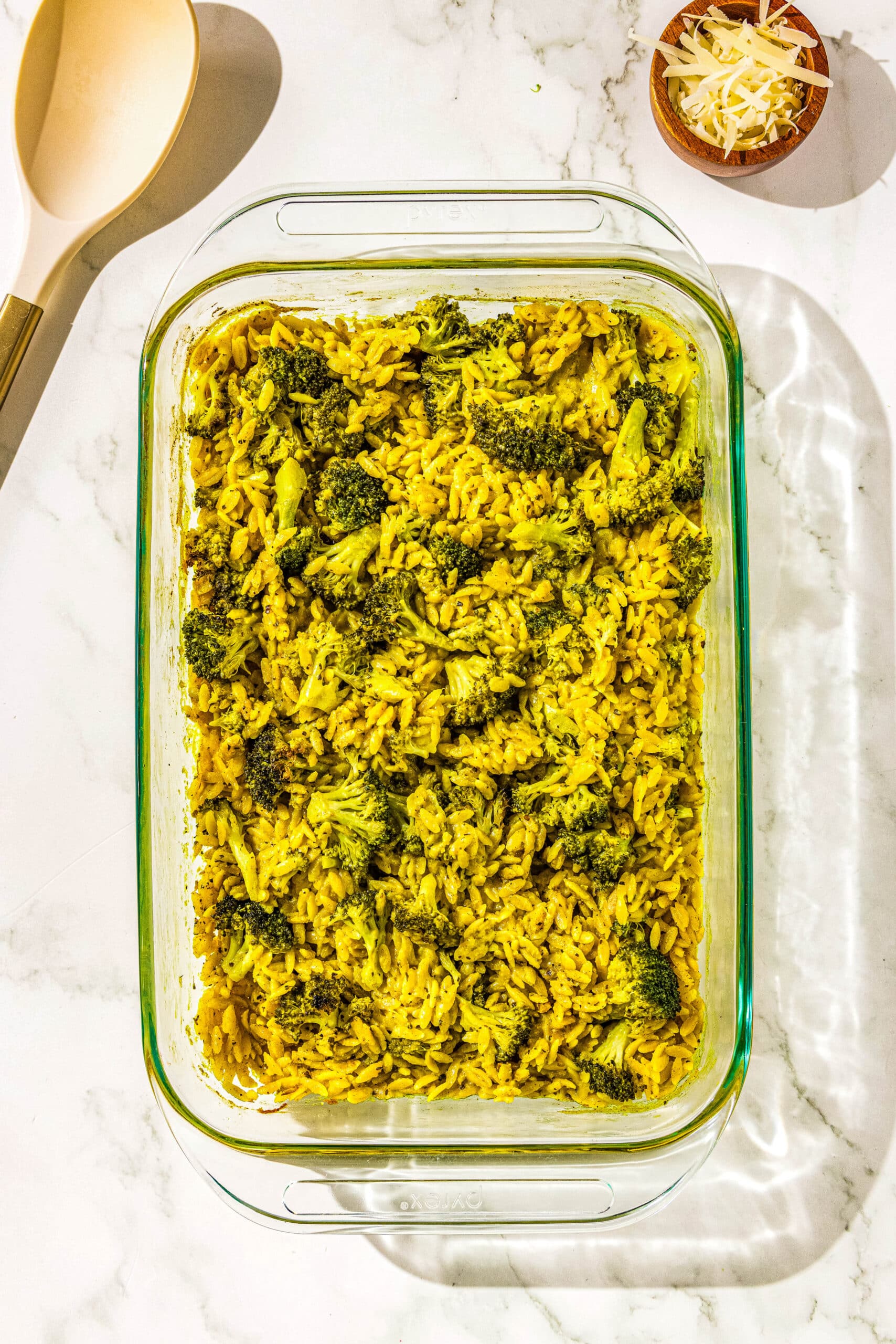 The final step of what the broccoli cheddar orzo dish looks like in the casserole dish after being in the oven.