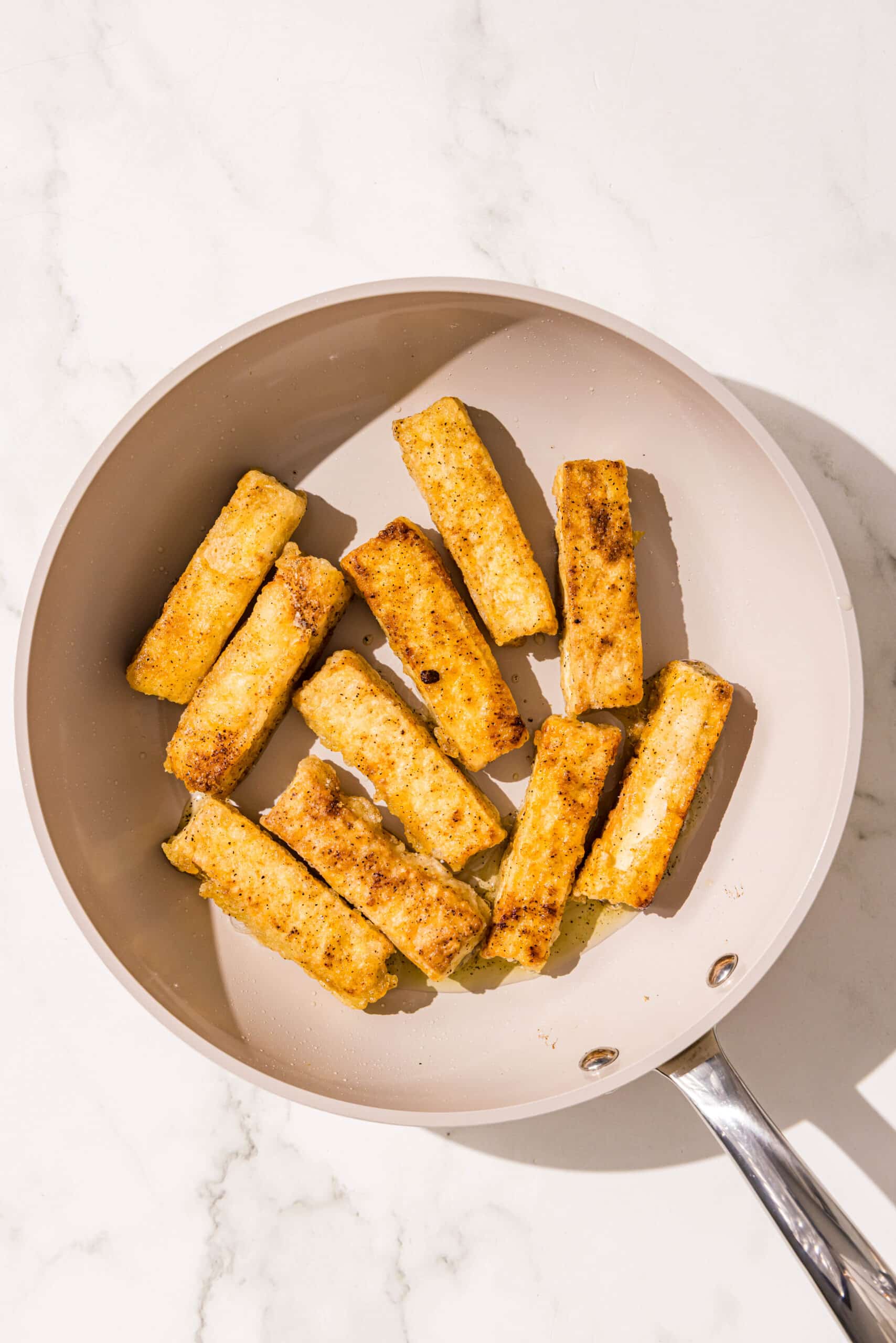 A grey pan filled with crispy tofu sticks.