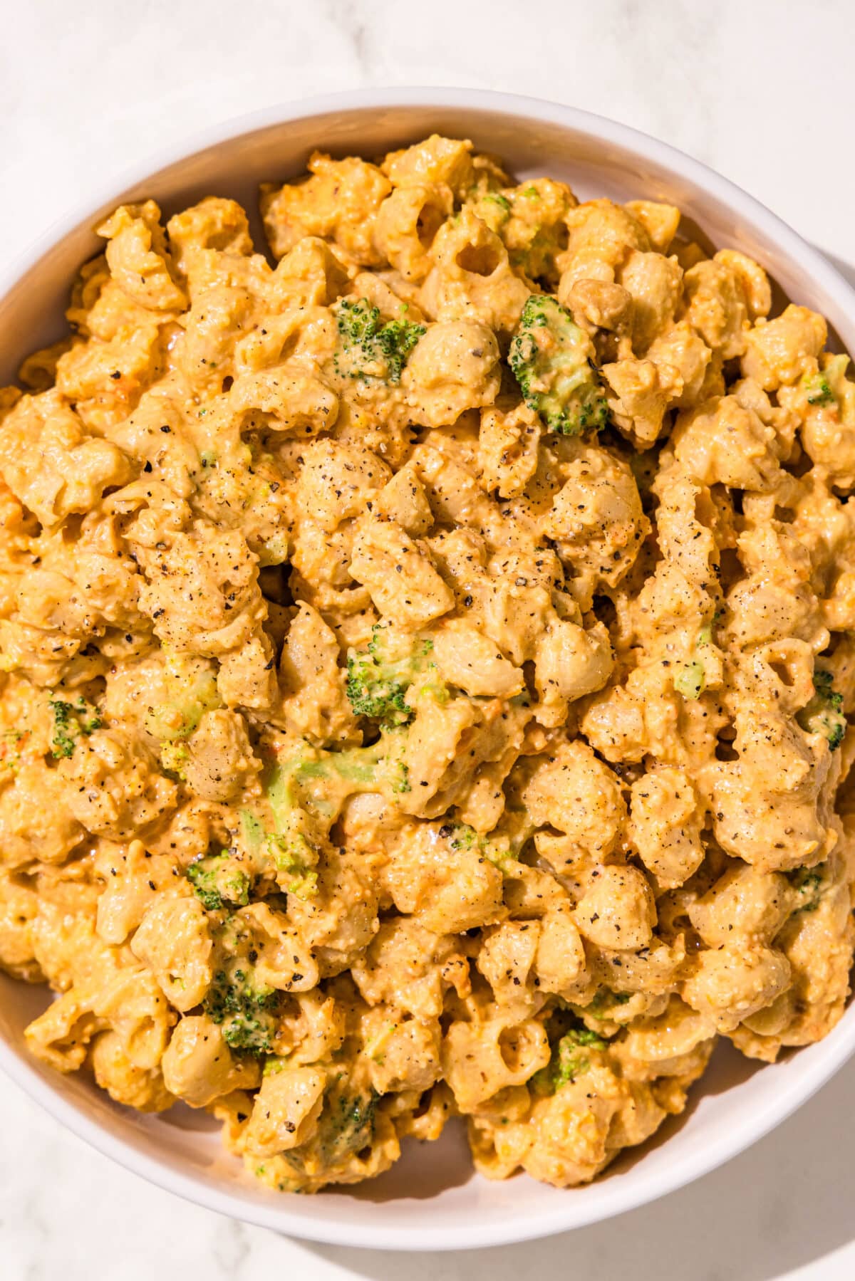 A bowl of mac and cheese with broccoli mixed in.