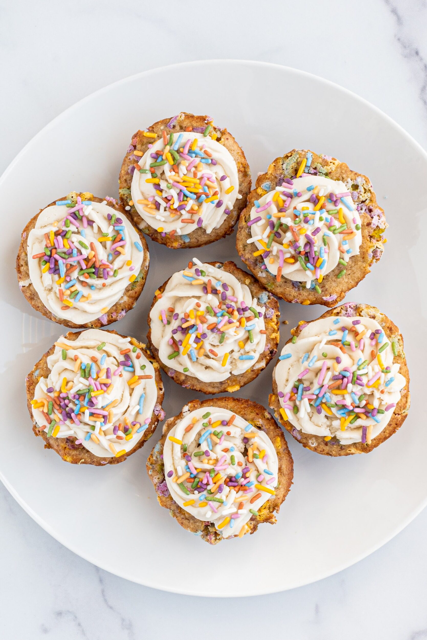 A plate of 7 funfetti muffins.