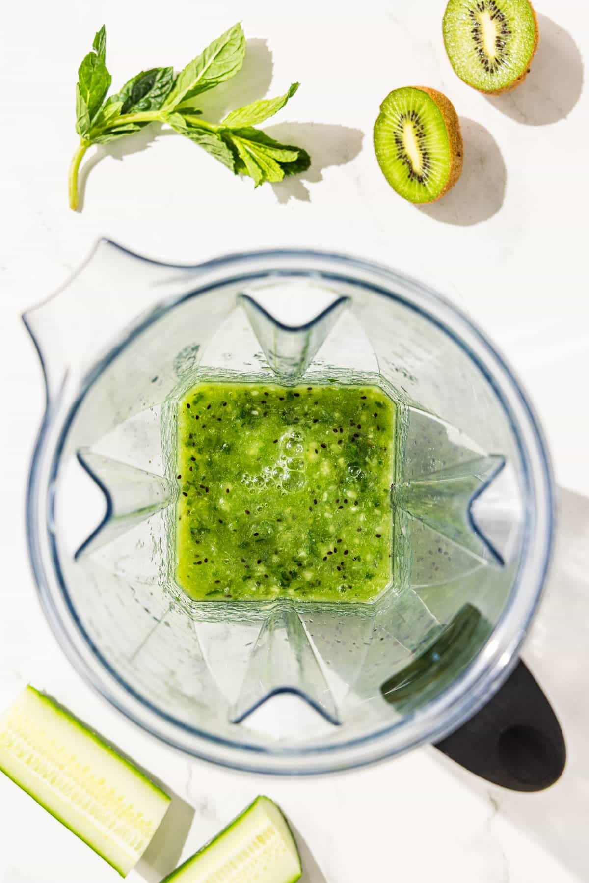 A blender filled with kiwi lime stress relief mocktail.