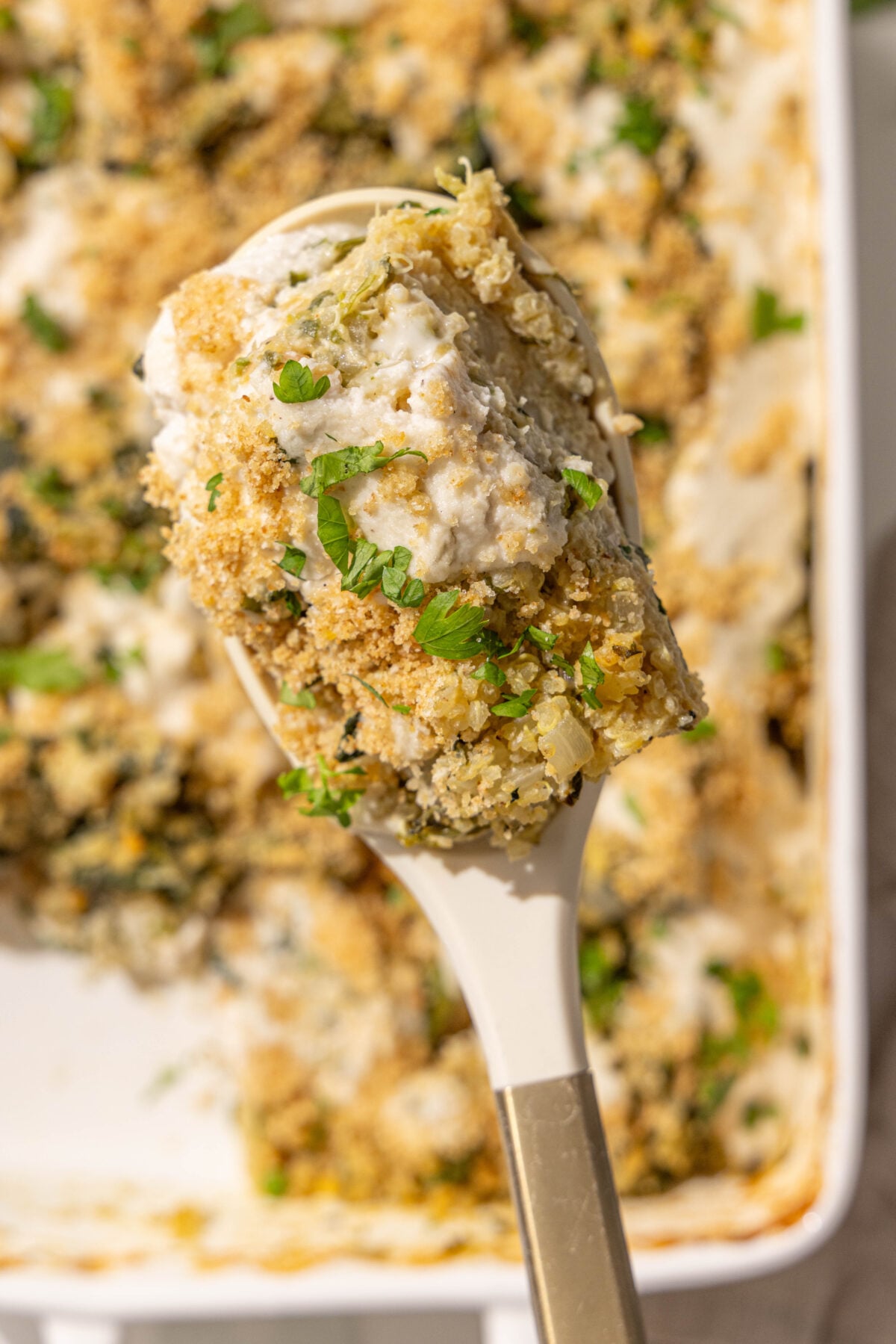A spatula holding a scoop of quinoa spinach casserole.