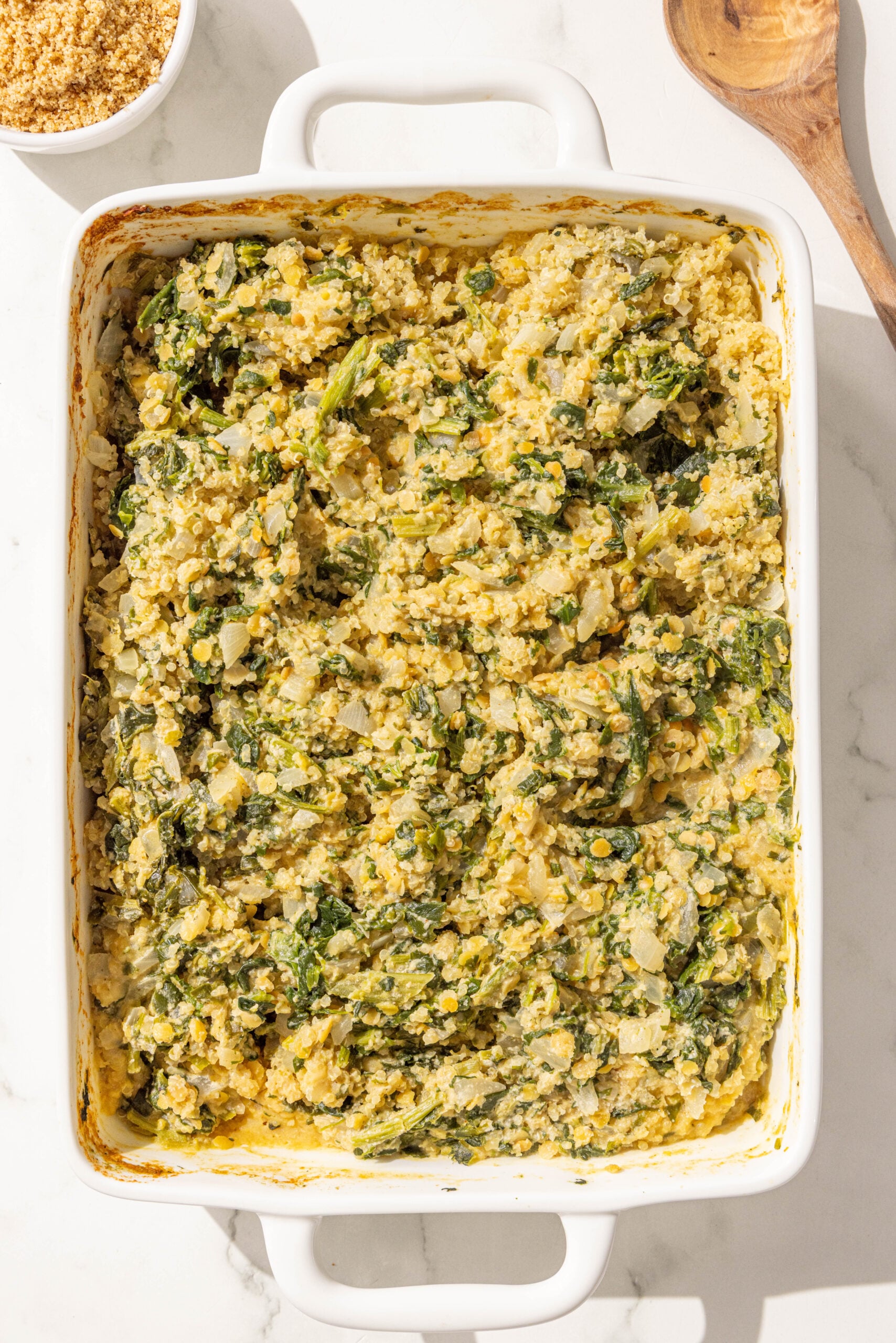 A 9x13 casserole dish with spinach quinoa casserole.